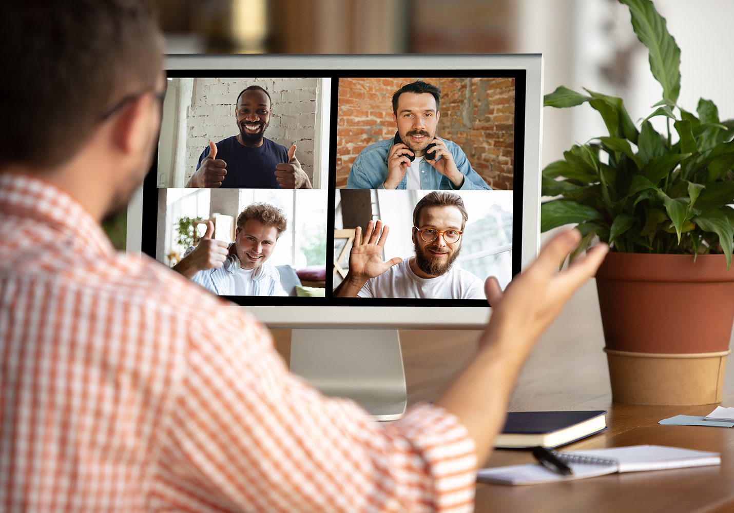 Remote meeting. Man working from home during coronavirus or COVID-19 quarantine, remote office concept. Young businessman, manager in front of monitor during online conference with colleagues and team.